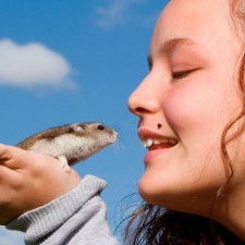 little girl talking to her mouse in her hand